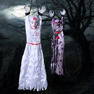 Creepy Halloween hanging nurse and clown decorations with chains in a dark forest setting