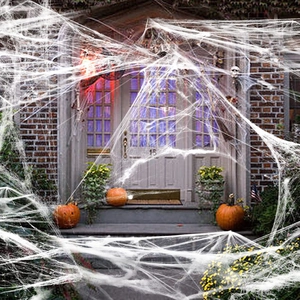 Elastic white artificial spider web decoration stretched over a festive house entrance