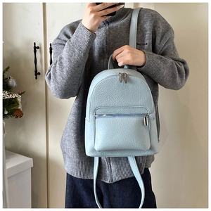 Close-up of a light blue mini backpack in pebbled leather with silver zipper details