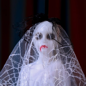 Close-up of Halloween ghost bride prop with skull face and white lace wedding veil