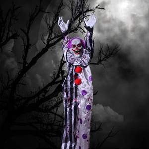 Hanging Halloween clown prop with glowing red eyes and bloody stripes in dark woods