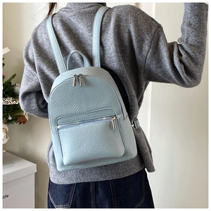Close-up of light blue lychee pattern leather backpack with silver metal zippers