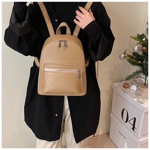 Litchi texture khaki leather backpack shown on a model in a stylish lifestyle setting