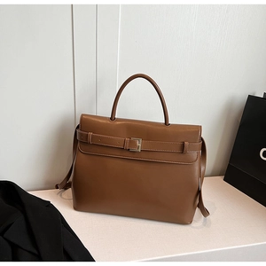 Detail of vintage brown leather handbag with metal buckle and adjustable shoulder strap