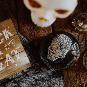 Halloween decorative plate with skull design on black creepy gauze fabric backdrop