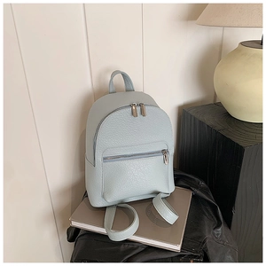 Detail shot of light grey blue pebbled leather backpack with metallic double zippers