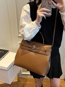 Vintage brown leather briefcase bag with top handle and crossbody strap in street style