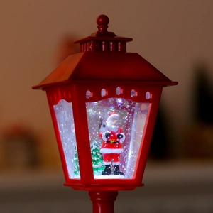 Detail of red Christmas lantern with Santa Claus, glowing LED light and swirling glitter