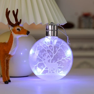 Macro shot of luminous Christmas ornament ball with deer silhouette and blue LED light