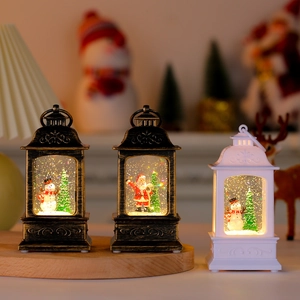 Gros plan de trois lanternes de Noël LED avec Père Noël, bonhomme de neige et effet neige