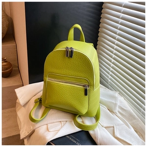 Detail of lime green textured leather mini backpack showing zippers and strap details