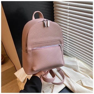 Detail of pink faux leather mini backpack showing refined litchi grain texture and zippers