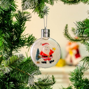 Detail of transparent Christmas ball with Santa Claus figurine and mini tree hanging on branch