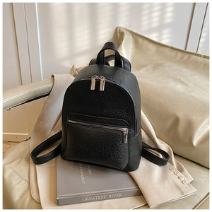 Detail of minimalist black pebbled leather backpack with silver metal zippers on top