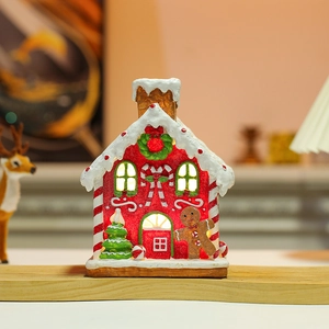 Glow-in-the-dark Christmas gingerbread house with warm lights and festive resin details