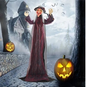 Life-size Halloween witch prop with glowing eyes in a spooky haunted castle yard scene