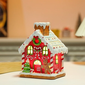 Close-up of glowing gingerbread house with snow-capped roof and festive candy details