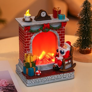 Detailed view of a glowing resin Christmas fireplace ornament with LED logs and a Santa chair