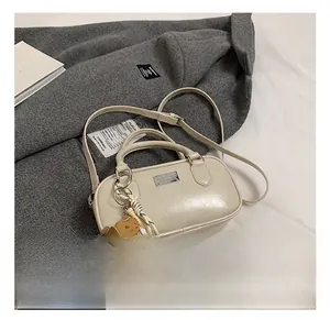 Detail of off-white bowling bag with creative baseball charm and silver logo plaque