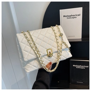 Close-up of white quilted leather texture with gold chain strap and square metal buckle