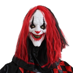 Macro view of glowing evil clown mask with red hair and LED eyes for Halloween decor
