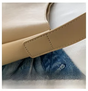 Close-up of beige PU leather shoulder bag showing precise double-stitch craftsmanship