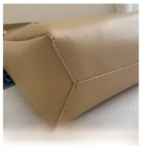 Close-up of precise stitching and premium PU leather texture on the beige tote bag base