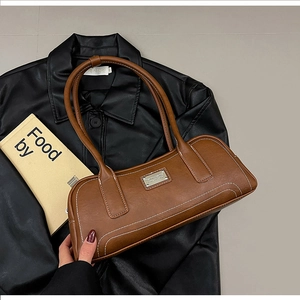 Detailed view of vintage brown baguette bag with white contrast stitching and logo