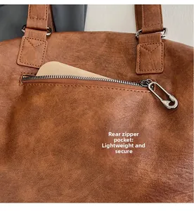 Close-up of brown PU leather tote bag featuring a pin-style zipper and back security pocket