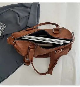 Detail of large dark brown tote bag interior showing capacity for a silver laptop
