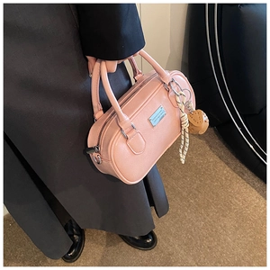 Detail of pink faux leather bowling bag with silver hardware and chic charms