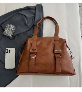 Close-up of caramel leather Boston travel bag with handles on a stylish lifestyle background