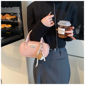 Pink glossy bowling bag with silver logo and baseball charm in a lifestyle kitchen setting