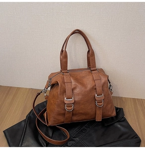 Detailed macro of brown Boston style tote bag with silver metal buckles and round handles