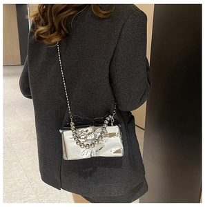 Bolso bandolera plateado metalizado con asa de cuentas combinado con chaqueta gris
