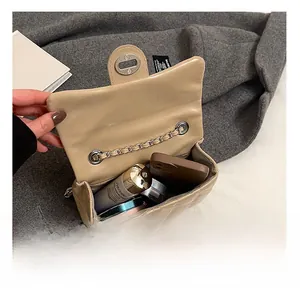Détail montrant la capacité interne du sac à chaîne matelassé avec téléphone et cosmétiques