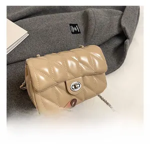 Détail du sac bandoulière beige matelassé avec bandoulière chaîne argentée et fermoir métal