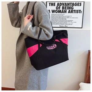 Detail of a large canvas tote bag with pink side panels and printed logo on grey coat