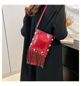 Detail of red tassel bucket bag with silver studs and polished leather finish