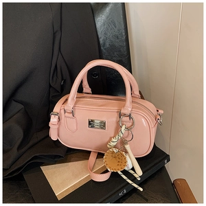 Macro view of soft pink bowling bag featuring a metallic logo and sporty baseball charm