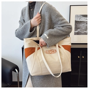 Detailed close-up of large canvas tote bag with orange contrast panels and FRIAICG text