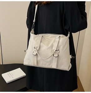 Detail of white large capacity tote bag featuring soft PU leather texture and shoulder strap