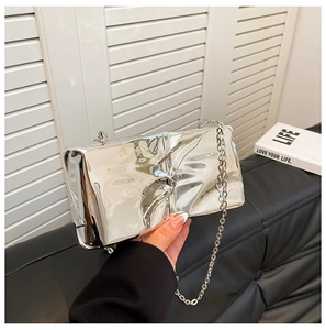 Detalle de bolso de noche acrílico plateado con efecto espejo y cadena