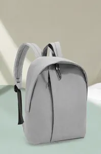 Detail of light gray backpack featuring water-resistant fabric and breathable mesh straps