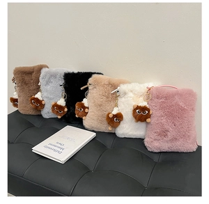 Multiple colors of fuzzy plush crossbody bags with cute furry eye bag charms on a bench