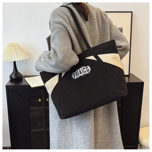Detailed back view of a large black and white contrast canvas tote bag with lettering