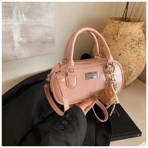 Detail of pink PU leather bowling bag showing silver plaque and decorative keychain charm