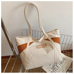 Detail view of canvas tote bag with brown patchwork and FRIAICG text in a metal basket
