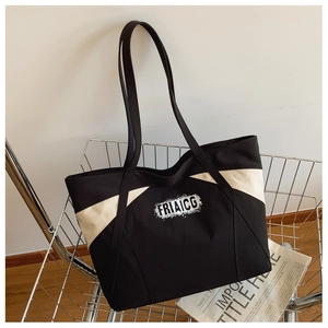 Close-up of color-block canvas tote bag with FRIAICG lettering in a metal trolley