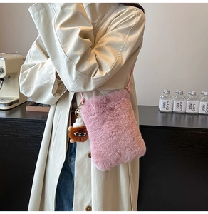 Pink plush crossbody phone bag with fluffy texture and cute decorative pendant detail